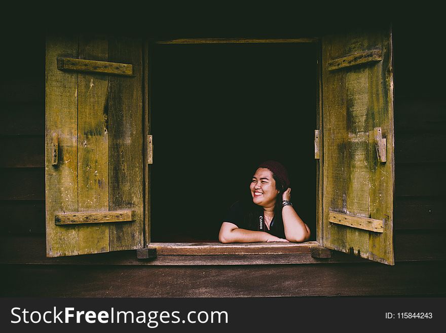 Woman in Black Top Sitting in Front of Opened 2-door Panel Window