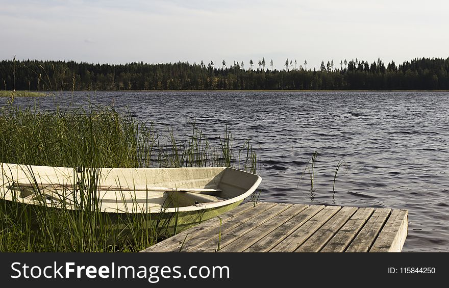 Brown Wooden Dock Beside White and Green Boat