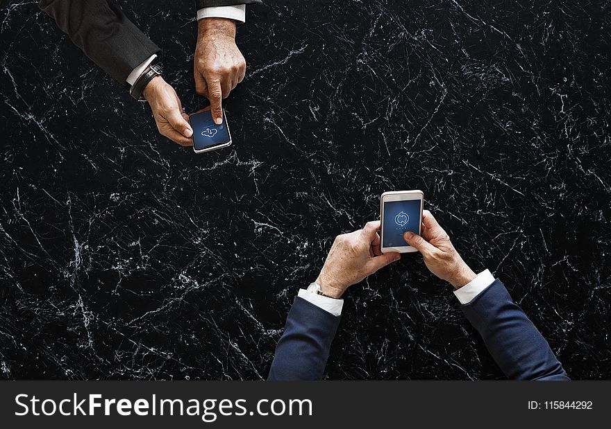 Two Person Holding White And Black Android Smartphones