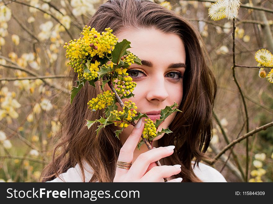 Woman Taking Photo With Holding Yellow Flower Buds at Daytime