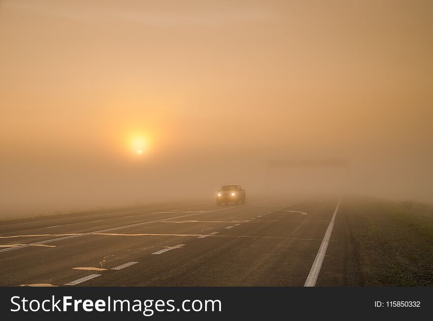 The light from the car`s headlights traveling the road in the mi