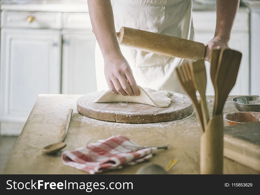 Man rolling and baking homemade dough in the kitchen. Closeup on baker`s hands preparing loaf of bread. Cooking and food preparation at home. Man rolling and baking homemade dough in the kitchen. Closeup on baker`s hands preparing loaf of bread. Cooking and food preparation at home.