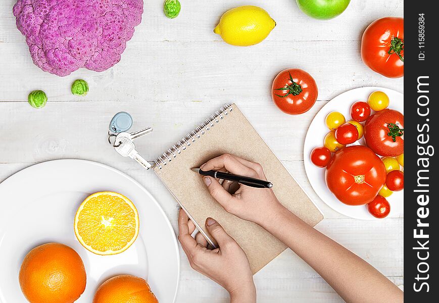 Nutrition Diet Food. Woman Writing Product Plan On Paper With Vegetables And Fruits On White Table. High Resolution