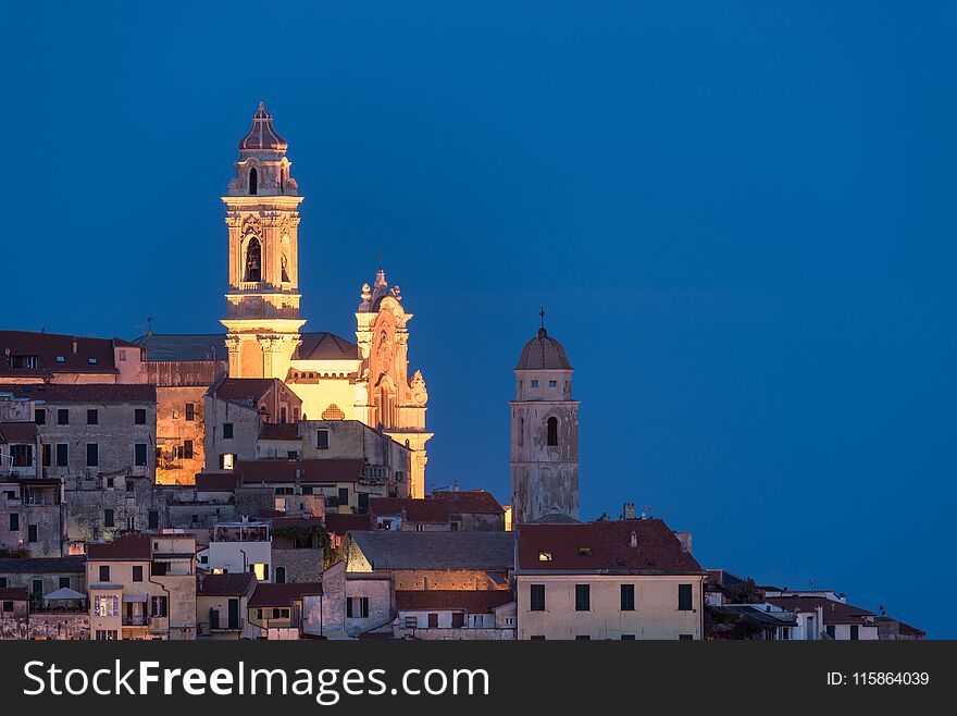 The old town of Cervo, Liguria, Italy, with the beautiful baroque church arising from the houses. Clear blue sky.