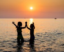 Silhouette Of Two Young Girl Jumping In Sea Royalty Free Stock Image