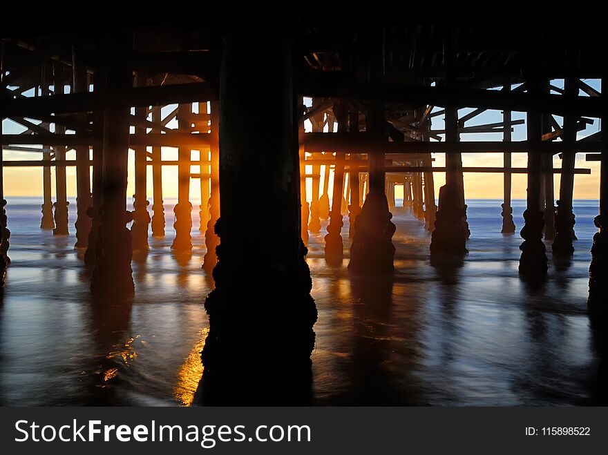 Pattern Of The Pylons Of The Pacific Beach Pier At Sunset.