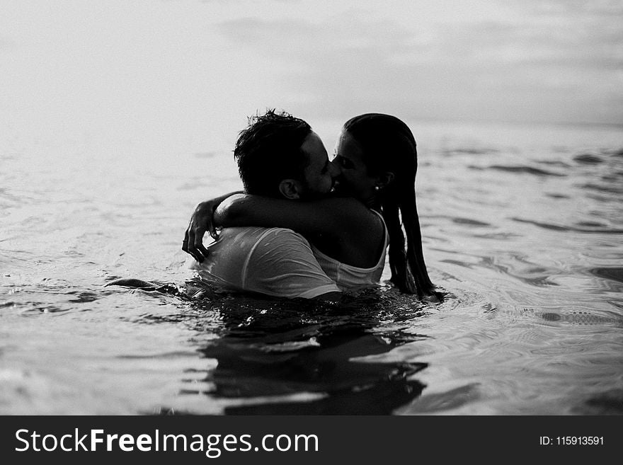 Man And Woman Kissing Together On Body Of Water