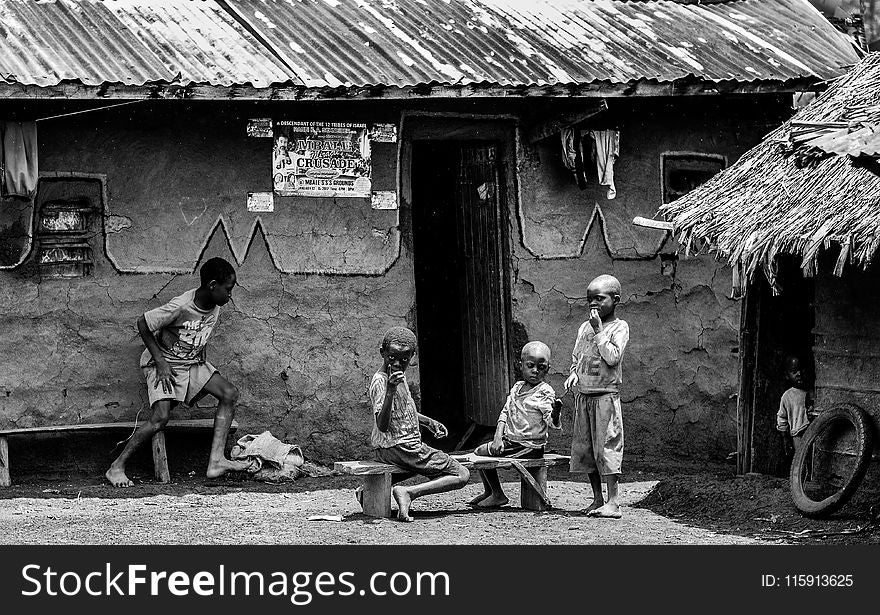 Greyscale Photo of Children in Front of a House at Daytime