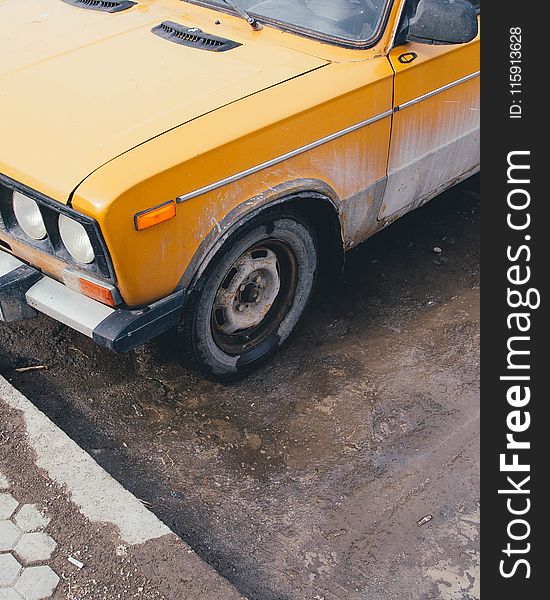 Yellow Car Parked Near Street Curb