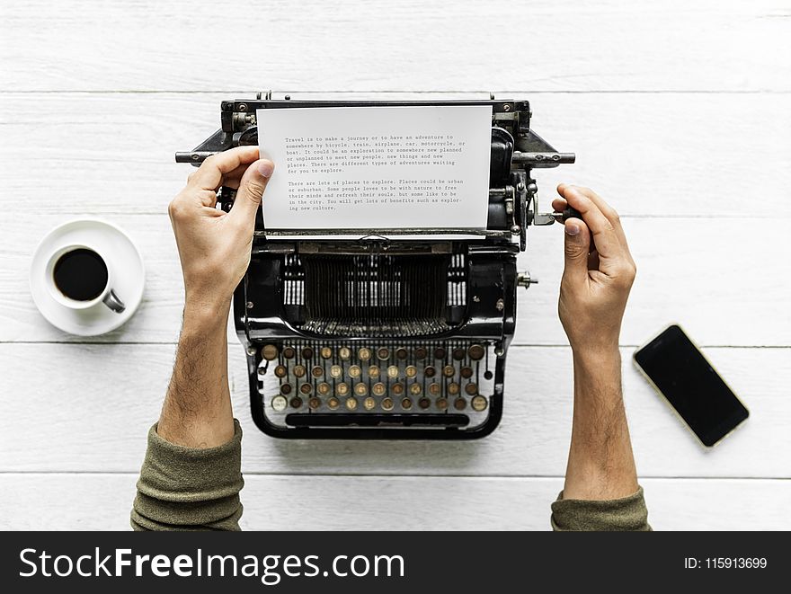 Person Holding White Paper and Typewriter