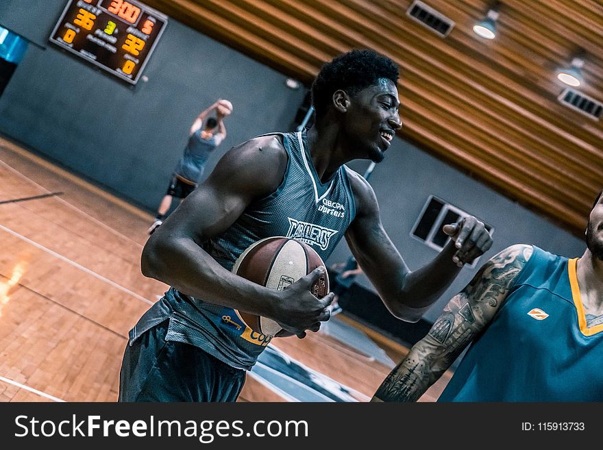 Basketball Player Holding A Brown Ball