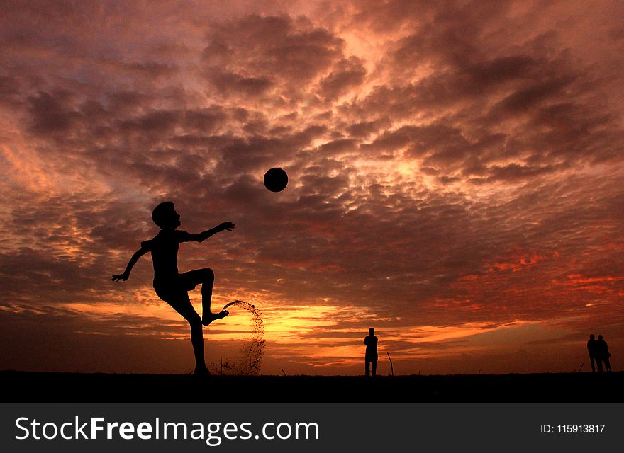 Silhouette of a Boy Playing Ball during Sunset