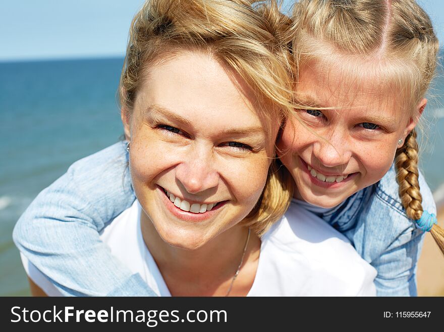 Happy mother and daughter laughing together outdoors.