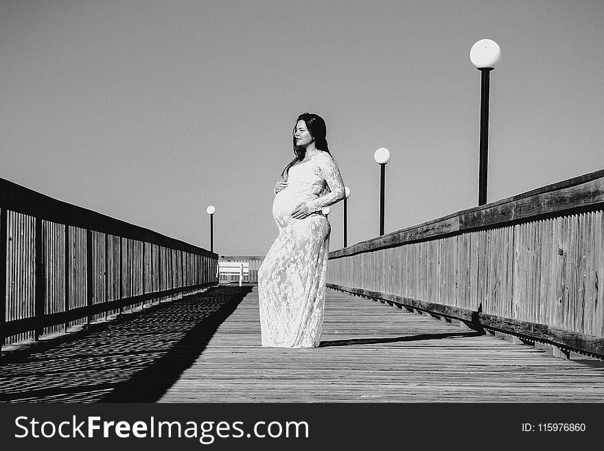 Grayscale Photo of Pregnant Woman Wearing Maxi Dress