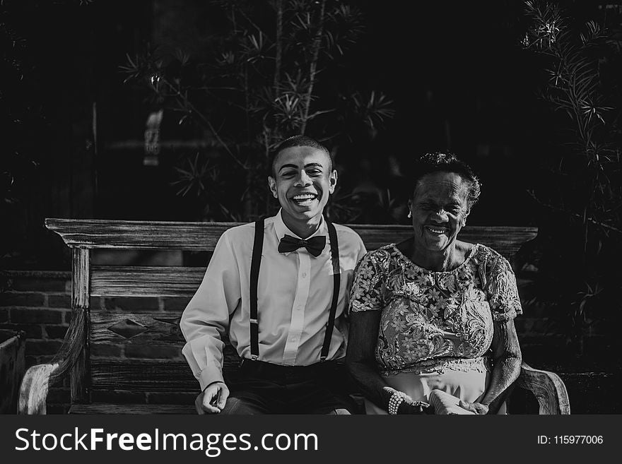 Man And Woman Sitting On Bench In Grayscale Photography