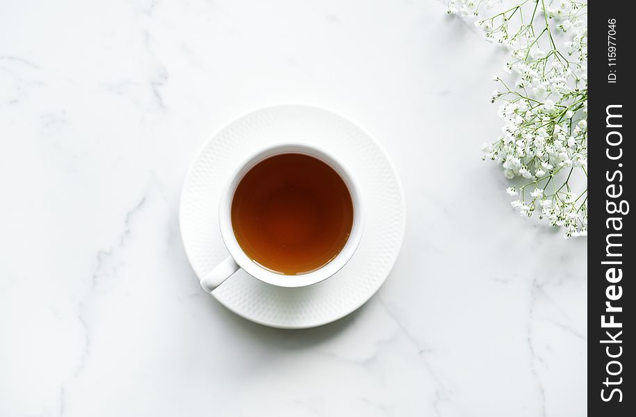 White Ceramic Teacup on Saucer With Brown Liquid