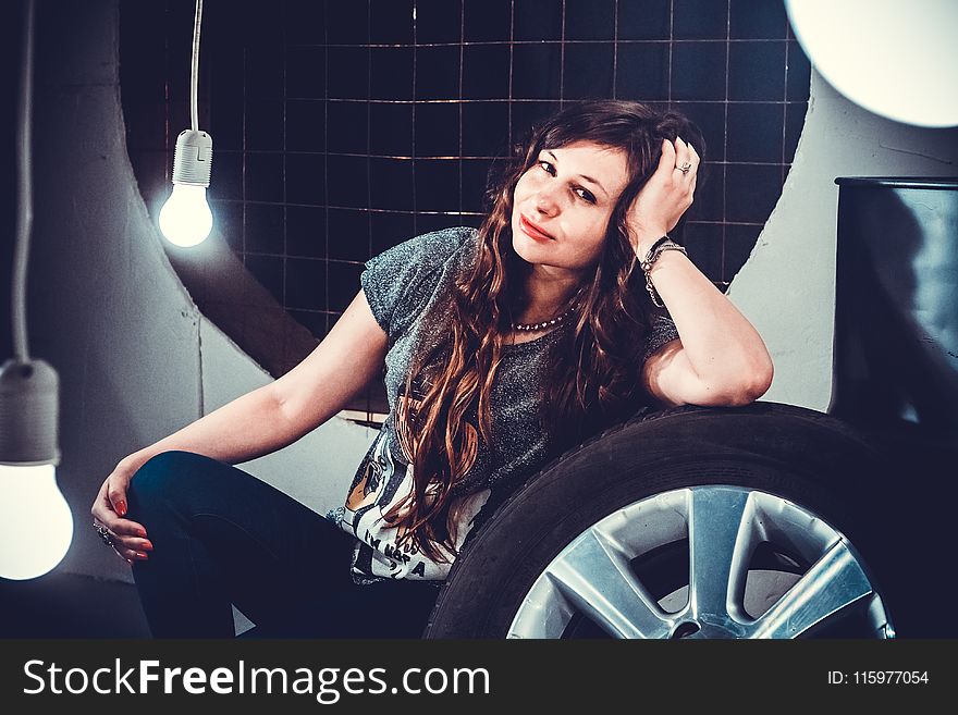 Woman in Gray Top Beside of Wheel With Tire