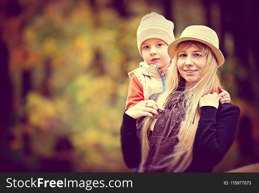 Shallow Focus Photo of a Woman Carrying a Toddler