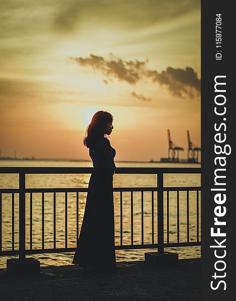 Silhouette Photo Of Woman Near Railing