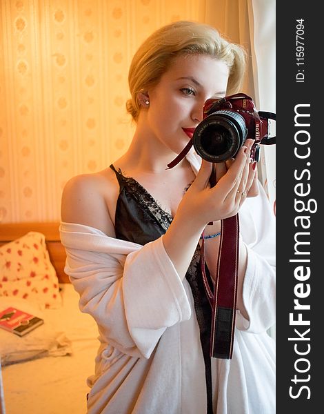 Woman Wearing Black Lace Floral Spaghetti Strap Dress Holding Black and Red Samsung Bridge Camera in Room