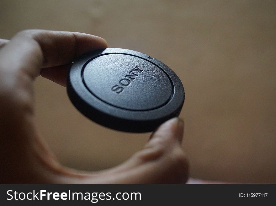 Person Holding Sony Camera Lens Cover