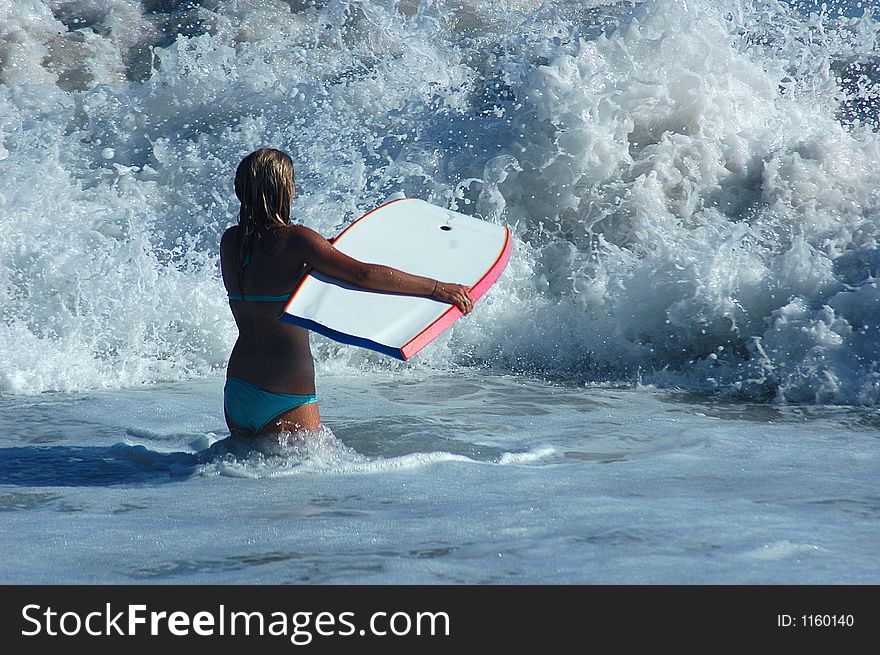 A girl with buddy board in the ocean. A girl with buddy board in the ocean