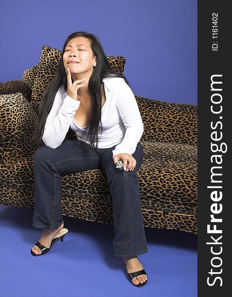 Woman thinking on couch with cell phone
