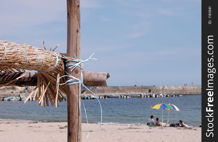 Aspect from a beach. Selective focus on the bamboo straw parasol.