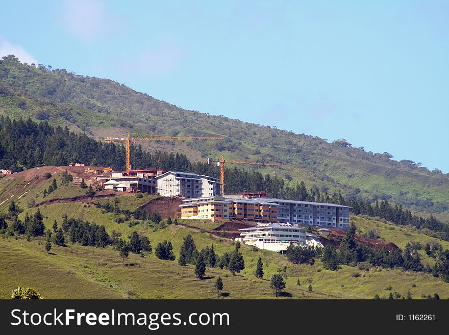 Building construction in the mountains with big cranes