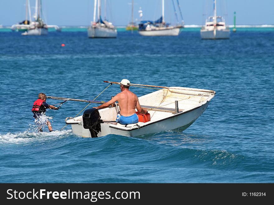 Boy learning waterski with instructor on a boat. Boy learning waterski with instructor on a boat