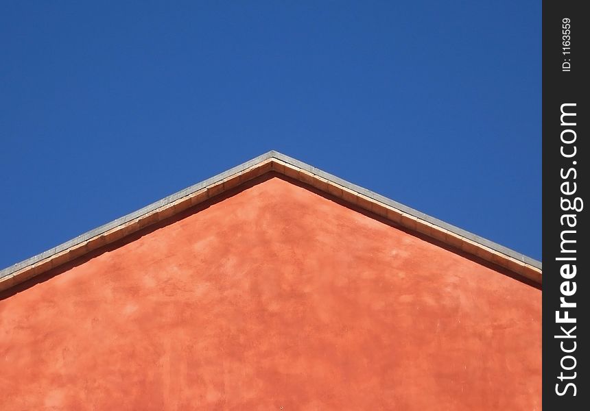 Architectural detail of a red house over a blue sky