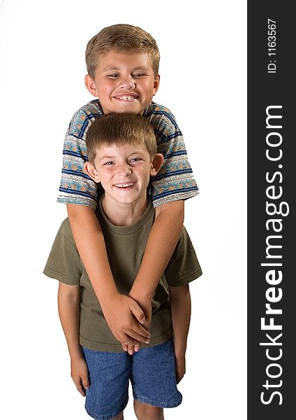 Big and little brother standing smiling isolated on a white background. Big and little brother standing smiling isolated on a white background.