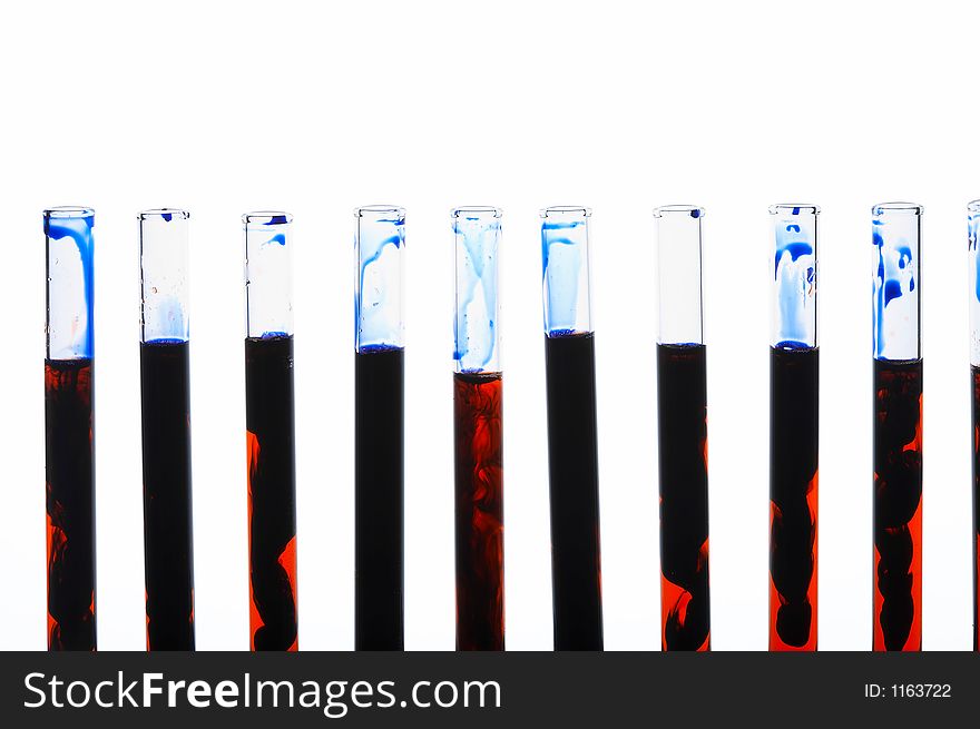 Glass test tubes standing in a line filled with strange black-orange liquid. Glass test tubes standing in a line filled with strange black-orange liquid