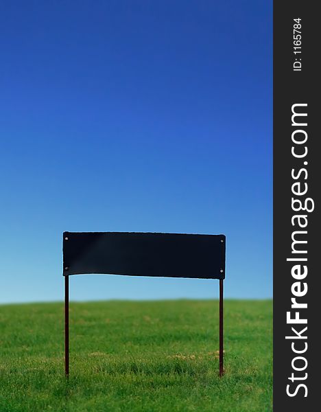 Blank sign on grass under perfect blue sky. Blank sign on grass under perfect blue sky