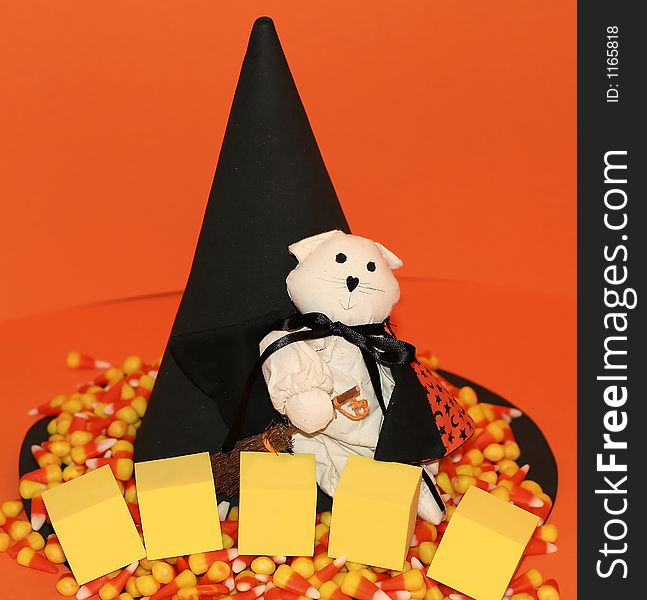Halloween scene with a cat dressed as a witch, a big witch's hat, candy corn and blank foam blocks. Halloween scene with a cat dressed as a witch, a big witch's hat, candy corn and blank foam blocks