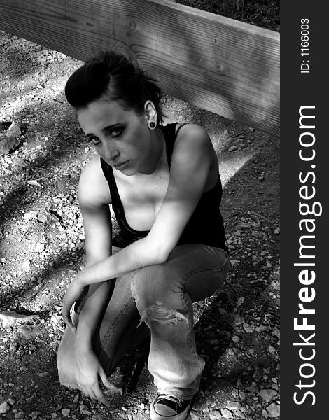 Punk woman kneeling in a lacey shirt - black and white. Punk woman kneeling in a lacey shirt - black and white.