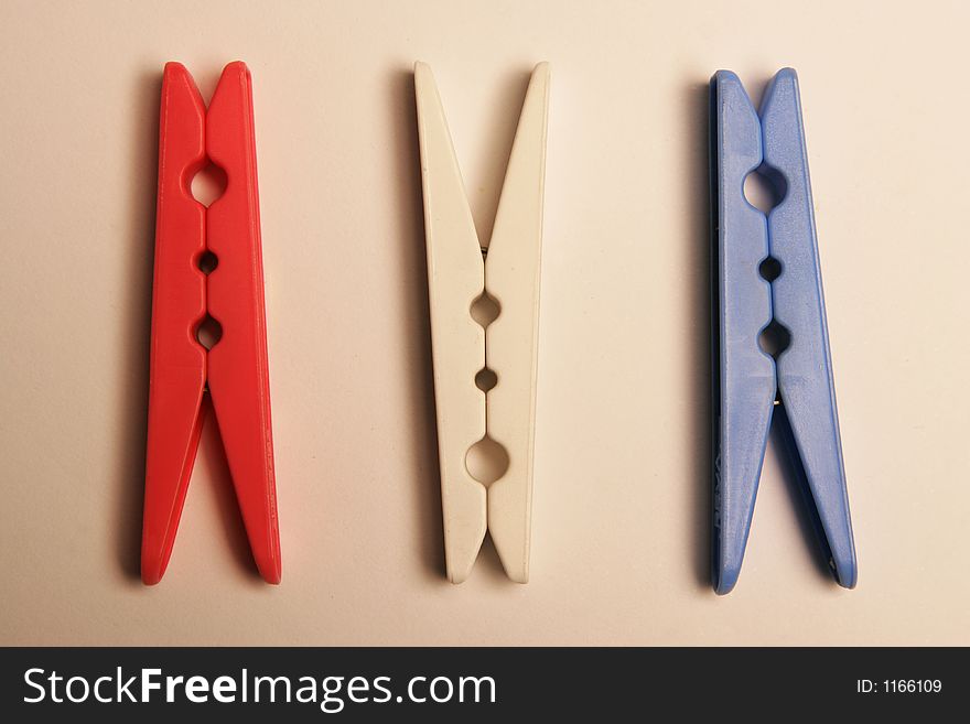 Three clothes pegs on a surface