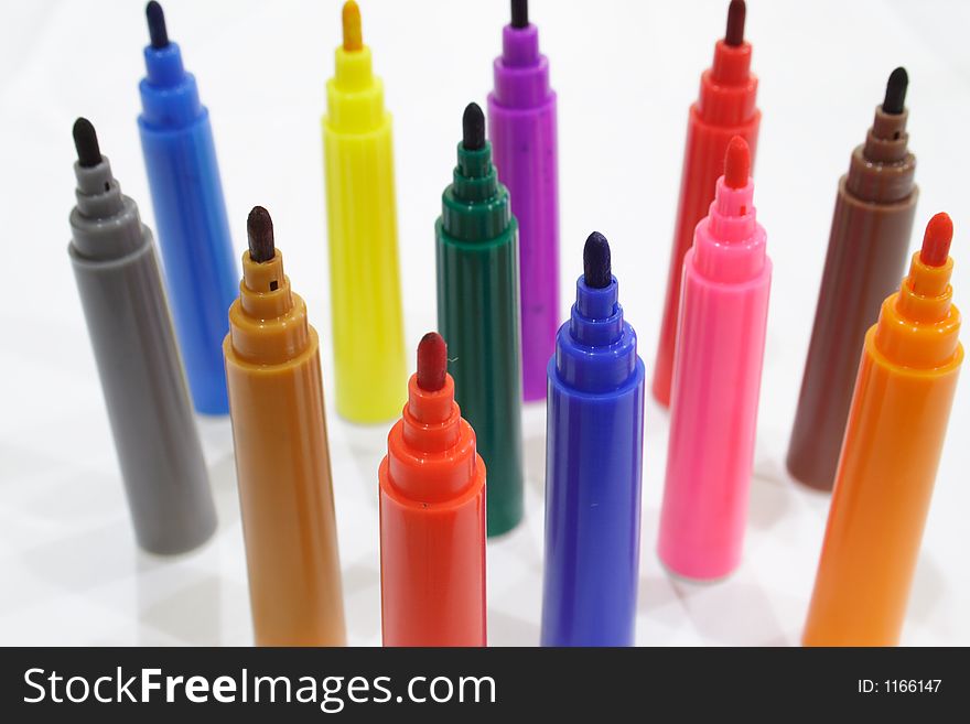 Close-up of colored markers standing with caps off