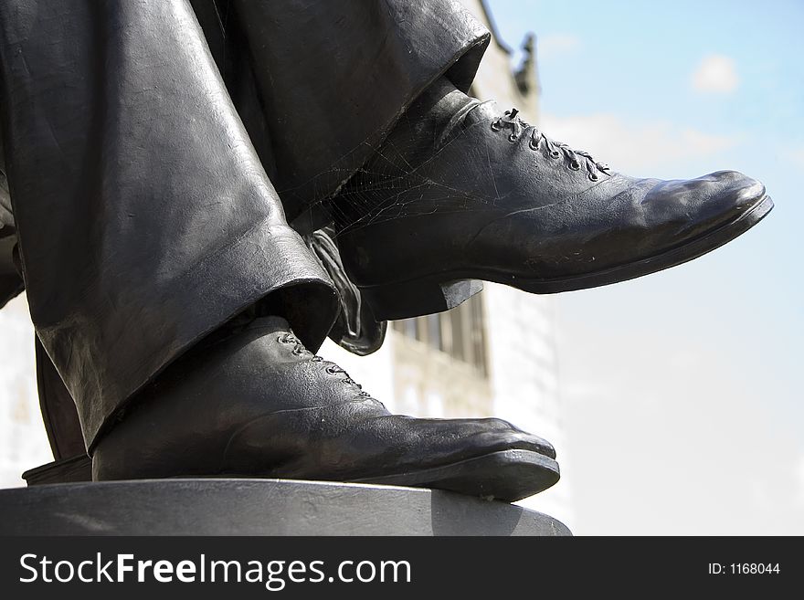 Feet of a statue with shoes on.