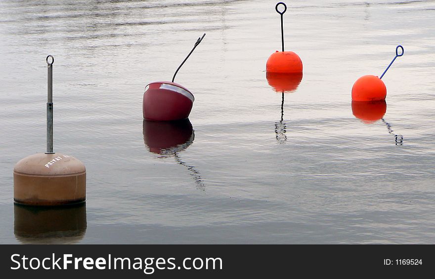 Four buoys reflecting in the water