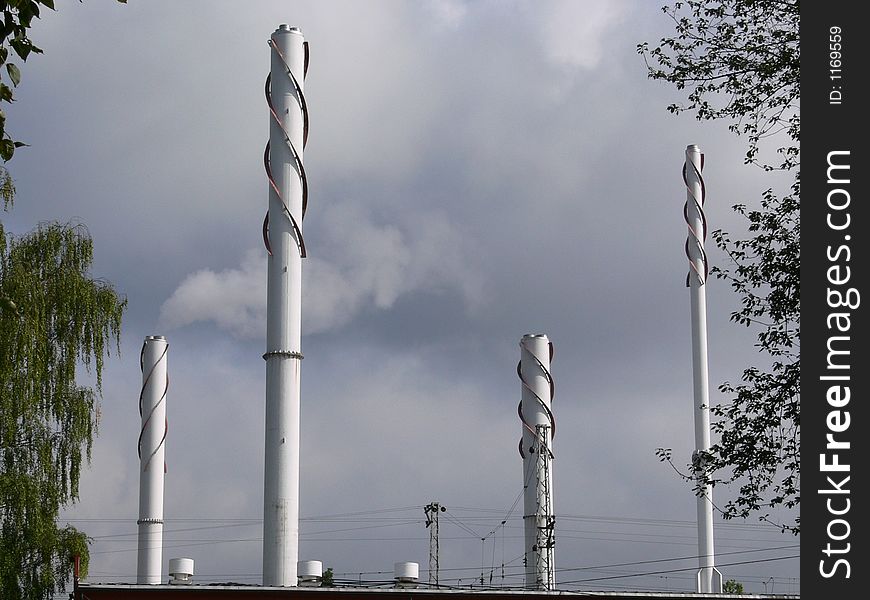 Industrial chimneys and factory fumes against a cloudy sky. Industrial chimneys and factory fumes against a cloudy sky