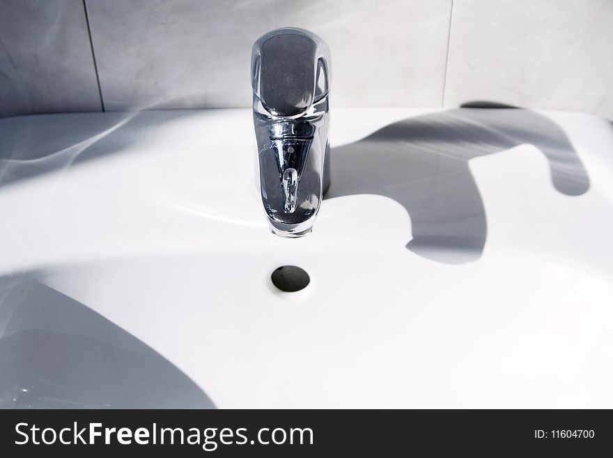 Ceramic white washing sink with a modern faucet