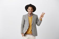 Showing Three Ways Or Choices. Studio Shot Of Pleased Successful African Boyfriend In Stylish Hat And Gray Jacket Stock Photos