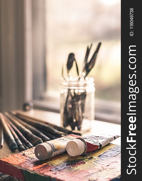 Shallow Focus Photography Of Two Ink Tube Bottles Near Glass Jar