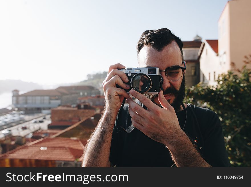 Man Holding Gray Point-and-shoot Camera