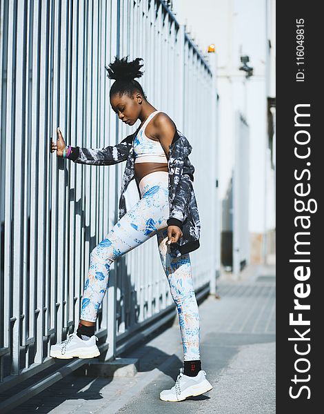 Woman Wearing White And Blue Pants And Pair Of Gray-and-white Low-top Sneakers