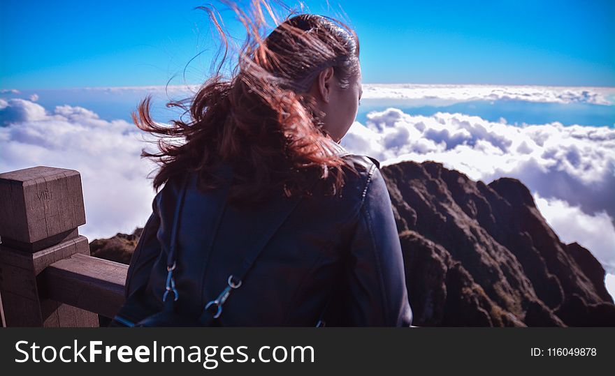 Woman Standing Near Cliff Above Clouds