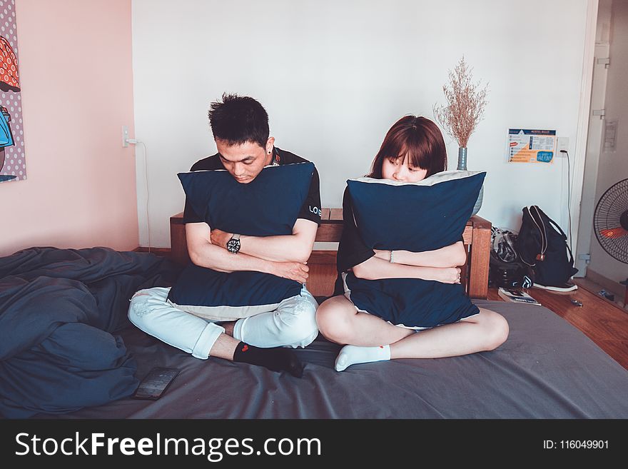 Man and Woman Sitting on Bed