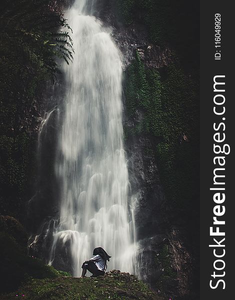 Photo Of Man Sitting Near Waterfalls