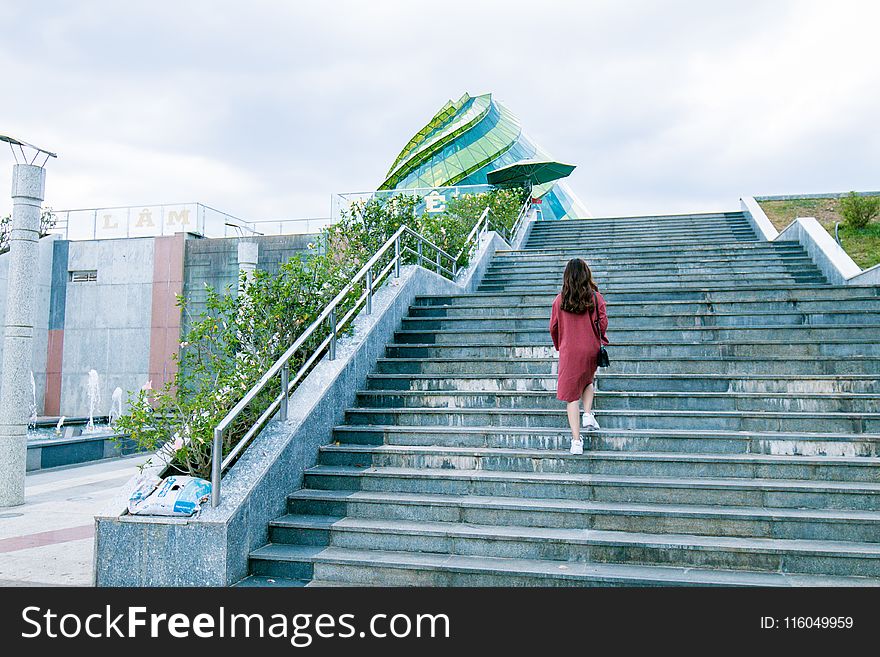Woman Wearing Red Dress on Gray Stairs